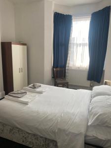 ein Schlafzimmer mit einem großen weißen Bett und blauen Vorhängen in der Unterkunft The keyberry in Newton Abbot