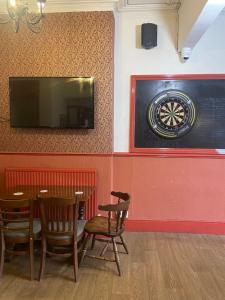 ein Esszimmer mit einem Tisch und einer Dartscheibe an der Wand in der Unterkunft The keyberry in Newton Abbot + 5 Fotos