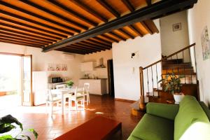a living room with a green couch and a table at Casa Madrigale in San Giovanni Valdarno