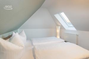 a small room with two beds and a window at Suite ODINS HALLE - Odins Blick Wohnung 8 - direkt am Privatstrand, Sauna, Garten in Lobbe