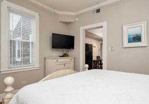 a bedroom with a white bed and a flat screen tv at King George Downtown Annapolis Getaway in Annapolis