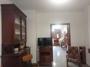 a living room with a tv and a wooden dresser at i giardini di Ailobran in Narbolia