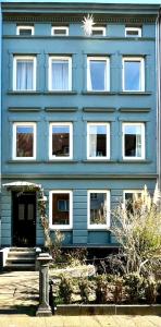 a blue building with white windows on the side of it at Boutique Apartment im charmanten Altbau in Lübeck +15 photos