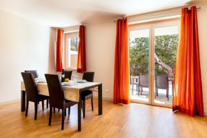 una sala da pranzo con tende arancioni e tavolo e sedie di Residenza Marano a Cupra Marittima