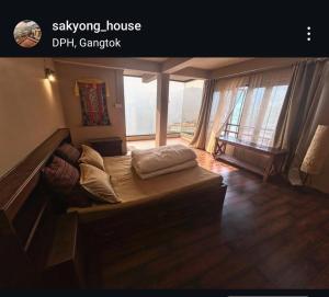 een woonkamer met een bank en een groot raam bij Sakyong house apartment in Gangtok