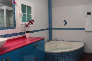 a bathroom with a tub and a sink and a vase with flowers at Casa amplia - Ideal para familias, terraza y relax in La Victoria de Acentejo