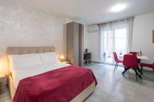 特拉尼Perlanera appartamenti的一间卧室,里面有一张床、一张桌子和几把椅子。