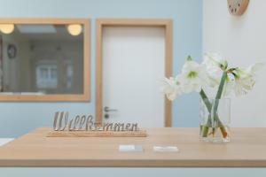 a vase of white flowers sitting on a table at Haus Bielefeld Zimmer 30a in Norderney