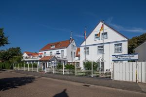 a white building with a fence in front of it at Haus Bielefeld Zimmer 30a in Norderney