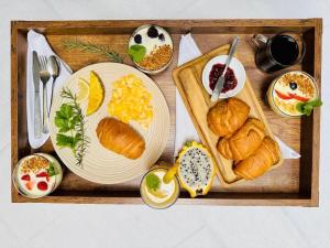 un vassoio di prodotti alimentari con croissant e altri prodotti per la colazione di Hotel Bombay a Baños