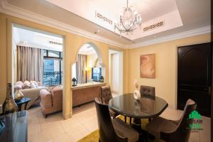 a living room with a table and a couch at Souk Al Bahar - Burj Khalifa - Dream View Holiday Home Rental in Dubai