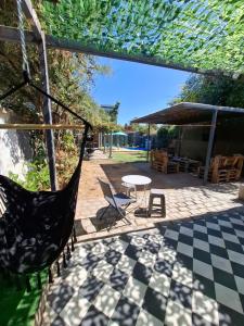 a patio with a hammock and a table and chairs at Hostal Sueños De Lujo in Talca