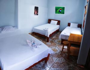 a room with two beds and a table in it at Tengana Hospedaje y Tours in Tarapoto
