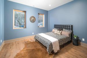 a blue bedroom with a bed and two windows at Group Getaway! 8,000-Sq-Ft Gem, Arcade + Theater in Beech Mountain