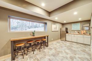 a kitchen with a bar with stools and a refrigerator at Group Getaway! 8,000-Sq-Ft Gem, Arcade + Theater in Beech Mountain