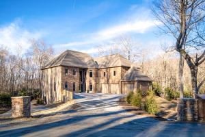 an old stone house with a road in front of it at Group Getaway! 8,000-Sq-Ft Gem, Arcade + Theater in Beech Mountain