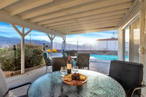 a table with wine glasses and a plate of food at 6 Mi to Joshua Tree Home with Outdoor Oasis and View! in Twentynine Palms
