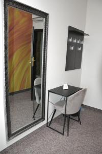 a mirror with a table and a chair in a room at Bursztynowa in Łuków