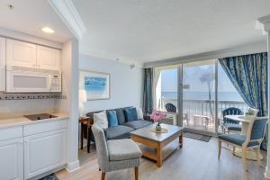 a living room with a couch and a table at Daytona Beach Studio Condo with Ocean Views! in Daytona Beach