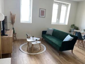 a living room with a green couch and a table at Évasion in Marmande
