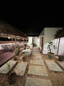 an outdoor patio with tables and potted plants at Hotel Kalos in Mahabalipuram