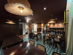 a restaurant with wooden tables and chairs and lights at Hotel Kalos in Mahabalipuram