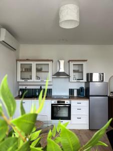 a kitchen with white appliances and green plants at Évasion in Marmande