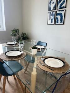 a dining room table with four chairs and glasses on it at Évasion in Marmande +7 photos