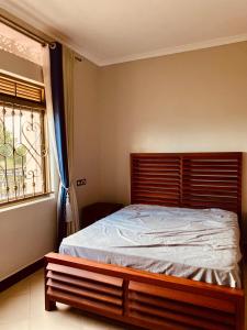 KyegegwaにあるKamu-Eco Safari Resortの窓とベッドフレーム付きの部屋のベッド1台分です。