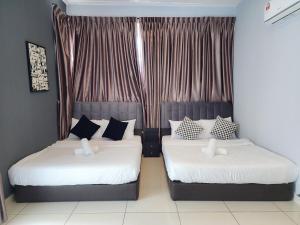 a bedroom with two beds with white and blue pillows at Near Tuas, Stadium, Legoland -- Stylish Homestay in Iskandar Puteri - 21pax by Cowidea in Gelang Patah