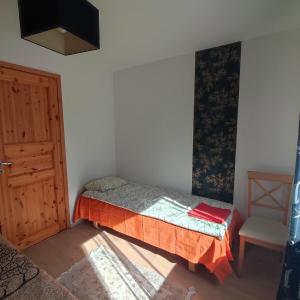 a small bedroom with a bed and a door at Vormsi ohvitseride maja korter nr 7 in Hullo