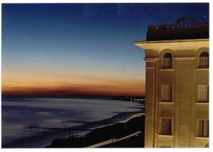 a building with a view of the ocean at sunset at Argentino Hotel Casino & Resort in Piriápolis