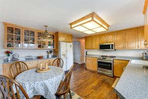 a kitchen with wooden cabinets and a table with a table cloth at Bring a Pet West Valley City House with Grill in West Valley City