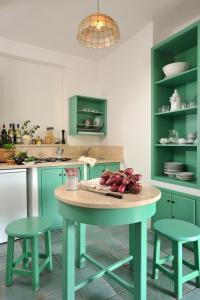 a kitchen with a table and two stools at Le Roccette Club in Tropea