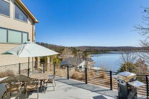 a patio with a table and chairs and an umbrella at BBQ-Ready Home in Lake of the Ozarks State Park! in Kaiser