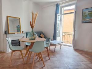 a dining room with a table and chairs and a vase at Lumière dorée- Studio élégant-central in Hyères