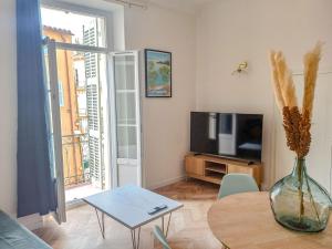 a living room with a vase on a table and a television at Lumière dorée- Studio élégant-central in Hyères