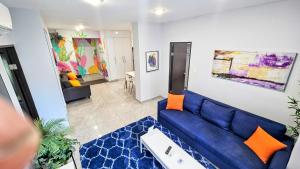 a living room with a blue couch and orange pillows at Somos Hotel San Juan in San Juan