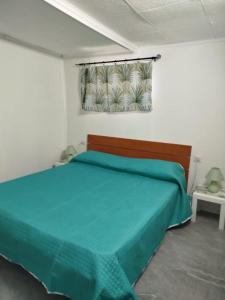 Villetta Mare في Terrauzza: غرفة نوم مع سرير مع لحاف أخضر +25 صورة