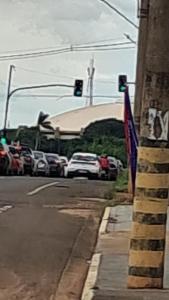 a traffic light on a city street with cars at Kitnet in Campo Grande