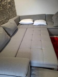 a large gray couch with two pillows on it at Appartement Nax in Nax