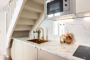 a kitchen with a sink and a microwave at Appartement Raffiné avec Jacuzzi et AC - 6P in Paris +9 photos
