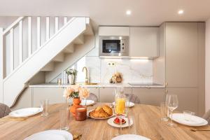 a kitchen with a wooden table with plates of food at Appartement Raffiné avec Jacuzzi et AC - 6P in Paris