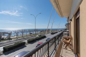 a balcony with a view of a road and the ocean at Vitamine Sea in Alexandroupoli