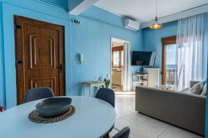a blue living room with a table and a couch at Vitamine Sea in Alexandroupoli