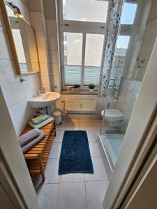 Un baño con lavabo, inodoro y ventana. en Ferienwohnungen in Schlossnähe, en Schwerin