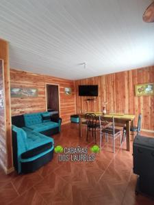 un soggiorno con un divano e un tavolo di Cabañas Dos Laureles a Coñaripe