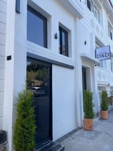 a white building with a door and two potted plants at Antalya D&D Terrace in Antalya