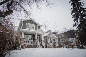 ein Haus mit Schnee auf dem Boden davor in der Unterkunft DOWNTOWN KINGBED 4Br FIREPLACE BIKELANE in Edmonton