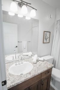 ein Badezimmer mit Waschbecken, Toilette und Spiegel in der Unterkunft DOWNTOWN KINGBED 4Br FIREPLACE BIKELANE in Edmonton + 37 Fotos